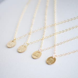 May include: Five gold necklaces with zodiac symbols as pendants. The symbols are Pisces, Aquarius, Libra, Virgo, and Sagittarius.