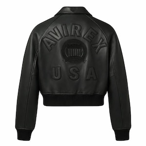 Puede incluir: Chaqueta bomber de cuero negro con el texto en relieve "AVIREX USA" en la espalda. La chaqueta tiene cuello, pu&ntilde;os y dobladillo de canal&eacute;. La parte trasera presenta un emblema circular con l&iacute;neas verticales.