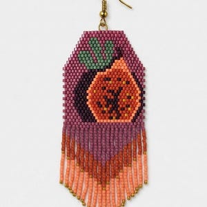 May include: A beaded dangle earring featuring a fig motif in shades of purple, orange, and green. The design is crafted from small seed beads with a long, layered fringe at the bottom in gradient tones of purple and peach, finished with a gold hook.