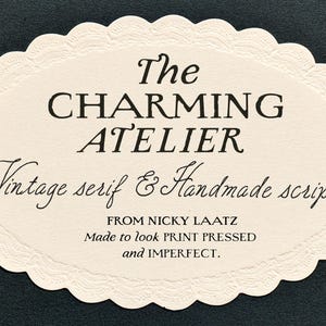 Op de afbeelding: Een ovaalvormig crèmekleurig papieren label met een geschulpte rand met zwarte tekst die luidt: The CHARMING ATELIER, Vintage serif & Handmade script, FROM NICKY LAATZ, Made to look PRINT PRESSED and IMPERFECT.