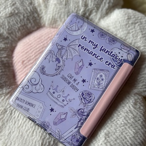 May include: A lavender-colored tablet case with a pink side. The case features a fantasy-themed design with a dragon, stars, crystals, roses, and the text "in my fantasy romance era" and "Give me a Shadow Daddy".