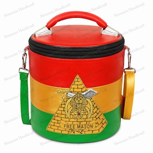 May include: A cylindrical bag featuring horizontal red, yellow, and green panels with a black zipper top and a red handle. An embroidered gold pyramid patch on the front displays a sphinx, a star, and the text "FREE MASON" with silver accents.