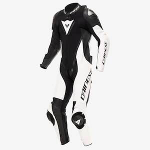 May include: A black and white leather motorcycle racing suit featuring the Dainese logo on the chest, collar, and legs. The suit includes protective shoulder and knee armor, a front zipper closure, and perforated leather panels on the arms and legs.
