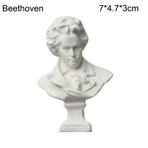 May include: A white bust of Beethoven, a classical composer. The sculpture is 7 inches tall, 4.7 inches wide, and 3 cm deep. The bust features a detailed depiction of Beethoven's face and attire, with the name "Beethoven" printed above.
