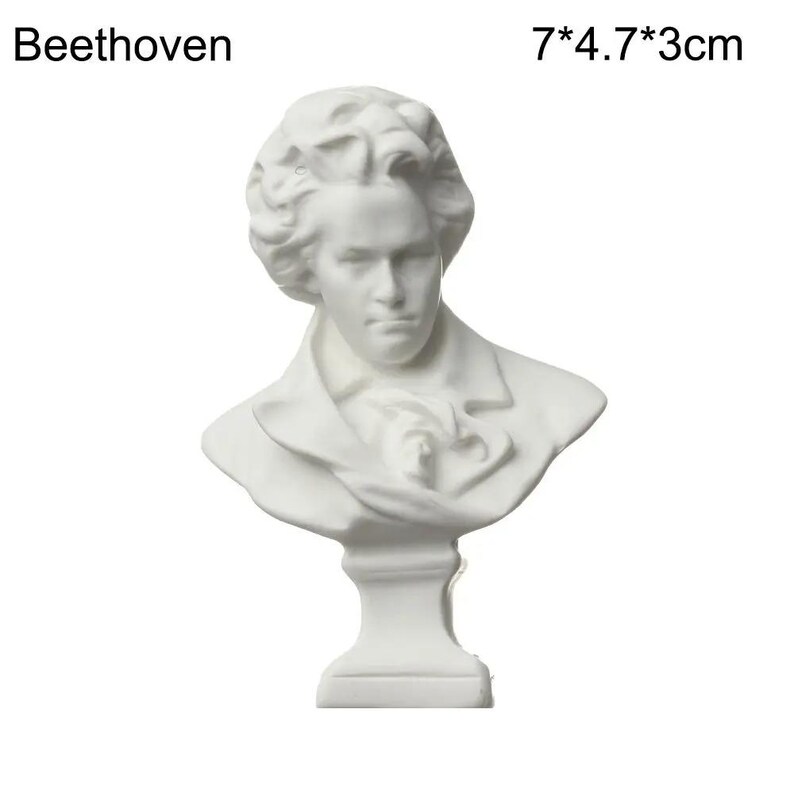 May include: A white bust of Beethoven, a classical composer. The sculpture is 7 inches tall, 4.7 inches wide, and 3 cm deep. The bust features a detailed depiction of Beethoven's face and attire, with the name "Beethoven" printed above.