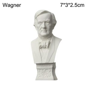 May include: A white bust of Wagner, 7 x 3 x 2.5 cm. The sculpture features a detailed depiction of a man's head and shoulders, with a bow tie and a suit. The base of the bust is inscribed with the name "Wagner".