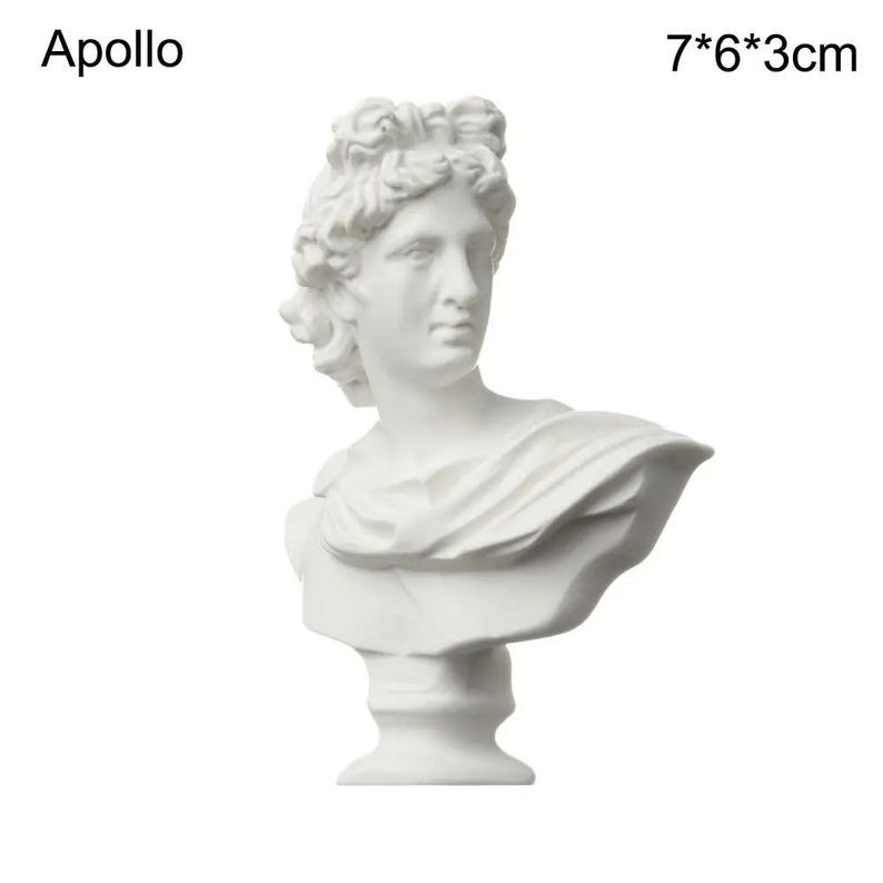 May include: A white bust of Apollo, a classical sculpture. The bust is 7 inches tall, 6 inches wide, and 3 inches deep. The sculpture features detailed facial features and draped fabric. The word "Apollo" is printed above the bust.