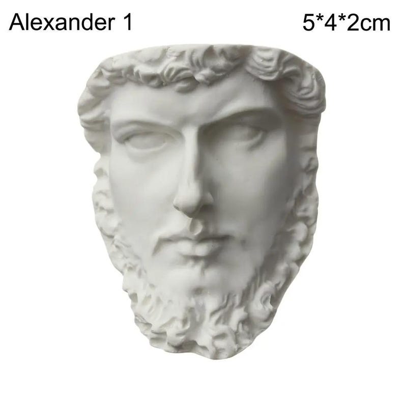 May include: A white bust of a man with a beard and curly hair. The bust is labeled "Alexander 1" and measures 5 inches by 4 inches by 2 inches. The sculpture has a detailed face with a stern expression.