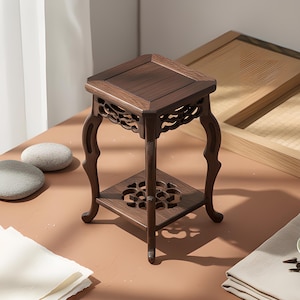 Könnte beinhalten: Kleiner, dunkelbrauner Holz-Ausstellungsständer mit quadratischer Ober- und unterer Ablage. Der Ständer hat verzierte, geschwungene Beine und dekorative Ausschnitte. Der Ständer ist etwa 30 cm hoch und dient zur Präsentation kleiner Objekte.