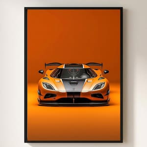 May include: A framed wall art print featuring a front-facing view of a high-performance sports car. The vehicle is painted in a vibrant orange with a bold black central stripe running along the bonnet and roof, set against a matching orange background.
