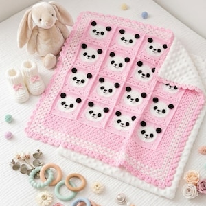 May include: A pink and white crochet baby blanket featuring panda faces. The blanket is surrounded by a white border and has a scalloped edge. A stuffed bunny, baby booties, and wooden toys are also in the image.
