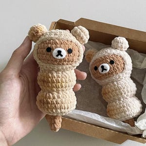 May include: Two handmade crochet bear dolls in a light beige colour with brown accents. The bears have small black eyes and a black nose. The dolls are in a cardboard box.