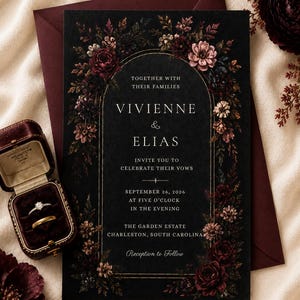 May include: A black wedding invitation card featuring a gold arched frame and dark floral illustrations. The text reads: Together with their families, Vivienne & Elias, invite you to celebrate their vows, September 26, 2026, at five o'clock.