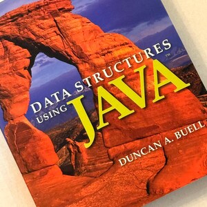 Pu&ograve; includere: Un libro di testo intitolato "Data Structures Using Java" di Duncan A. Buell. La copertina presenta un'immagine vibrante di una formazione rocciosa rossa sotto un cielo blu, con la parola "JAVA" in grandi lettere gialle.