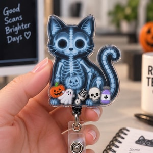 Op de afbeelding: Een doorzichtige acryl badgehouder met een blauwe röntgenillustratie van een kat met een zichtbaar skelet. Het ontwerp bevat kleine kleurrijke bedeltjes van een pompoen, een wit spookje, een ruggengraat, een schedel en een paars medicijnflesje.