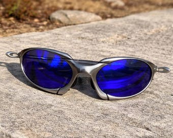 Gafas de sol Oakley estilo vintage con montura metálica de los 90 (años 2000), polarizadas, deportivas, con lentes Prizm rojas.