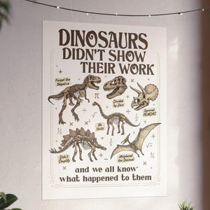 May include: A white wall poster featuring brown dinosaur skeletons and mathematical symbols. The text reads: DINOSAURS DIDN'T SHOW THEIR WORK, Forgot the Negative, Divided by Zero, Ignored PEMDAS, No Units, Didn't Simplify, Misplaced the Decimal, and we all know what happened to them.
