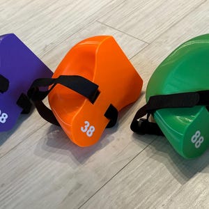 May include: Three wedge-shaped foam blocks in purple, orange, and green, each featuring a black adjustable strap and a white printed number on the side. The purple block is marked 98, the orange block is marked 38, and the green block is marked 88.