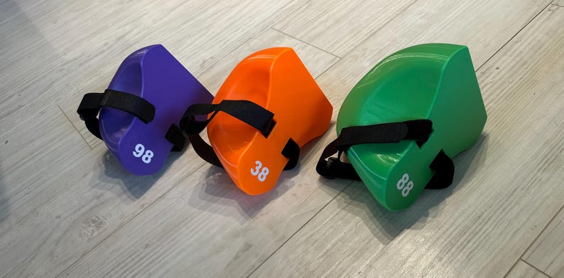 May include: Three wedge-shaped foam blocks in purple, orange, and green, each featuring a black adjustable strap and a white printed number on the side. The purple block is marked 98, the orange block is marked 38, and the green block is marked 88.