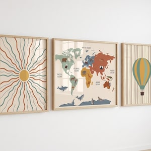 Pode incluir: Três impressões de arte emolduradas com acabamento em madeira clara. As impressões apresentam um design de explosão solar, um mapa-múndi com ilustrações de animais e um balão de ar quente. A paleta de cores inclui bege, laranja, verde-azulado e castanho.