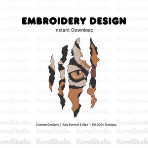 May include: An embroidery design featuring a tiger eye peering through four vertical claw marks. The design uses orange, black, and brown thread colors. Text at the top reads EMBROIDERY DESIGN Instant Download, and at the bottom Custom Designs | Any Format & Size | 50,000+ Designs.