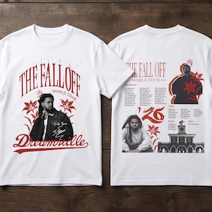 May include: A white short-sleeve t-shirt featuring a front graphic with the text THE FALL OFF WORLD TOUR and Dreamville, alongside a portrait of J. Cole. The back displays tour dates, a portrait, and the text THE FALL OFF WORLD TOUR '26.