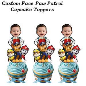 Op de afbeelding: Op maat gemaakte Paw Patrol cupcake toppers met een kindergezicht, Paw Patrol-personages en blauw geglazuurde cupcakes. De cupcakes hebben pootafdrukversieringen en blauwe linten, perfect voor een feestje.