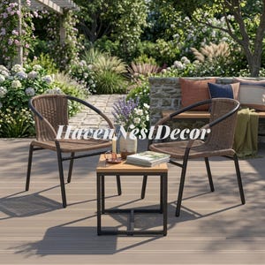 May include: Two brown woven chairs with black metal frames and a square side table with a light wood top and black metal base. On the table sits a ceramic vase with lavender and white flowers, a small candle, and a stack of books on a deck.