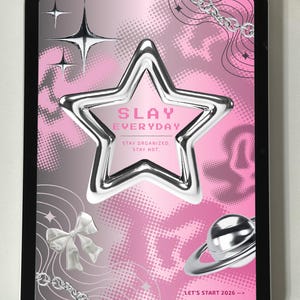 Puede incluir: Una tableta digital muestra un diseño gráfico rosa y plateado. Una gran estrella brillante es el punto focal, con las palabras "SLAY EVERYDAY" en su interior. Elementos adicionales incluyen estrellas, un lazo, una cadena y un planeta. También está presente el texto "STAY ORGANIZED. STAY HOT."