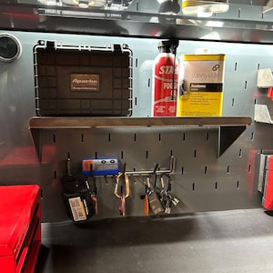 May include: A workshop scene featuring a black Apache case, a red can of "STAR FOG", and a yellow "sunnyside" Acetone container. A metal shelf holds these items, with keys and tools hanging below.