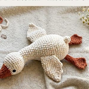 Può includere: Uno schema per uncinetto intitolato No-Sew Little Goose Crochet Pattern Easy PDF Tutorial Instant Download che mostra un'oca all'uncinetto color crema con becco e zampe color ruggine, accompagnata da un gomitolo, un cestino e uncinetti in legno.