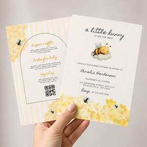 Puede incluir: Dos tarjetas de invitación para baby shower blancas con patrones de panal amarillos e ilustraciones de abejas. El texto dice a little hunny is on the way, Amelia Henderson, 10 de noviembre, 7:00 PM, 123 anywhere street, any city, e incluye un código QR.