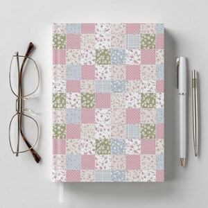 May include: A notebook with a patchwork design featuring squares of floral, polka dot, and plaid patterns in pink, green, and blue. A pair of eyeglasses and two pens are next to the notebook.