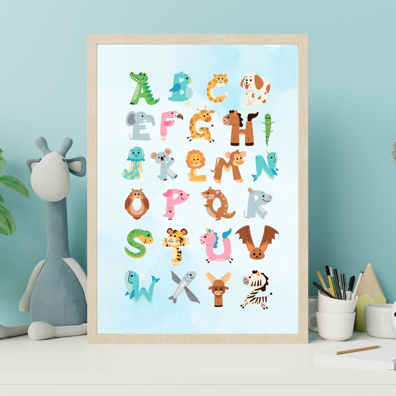 May include: A framed alphabet print featuring colorful animal illustrations for each letter. The artwork has a light blue watercolor background and a wooden frame. The animals include an alligator, a dog, a zebra, and many more.