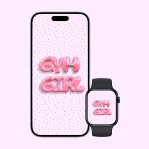 May include: A smartphone and smartwatch display the words "GYM GIRL" in pink, bubble-style letters against a dotted pink background. The phone is silver and black, and the watch is black.
