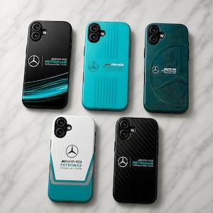 Peut inclure: Cinq coques de téléphone avec le logo AMG Petronas Formula 1 Team. Les coques sont noires, turquoise, blanches et vert foncé. Chaque coque a un design différent, avec une texture en fibre de carbone et un motif à rayures.