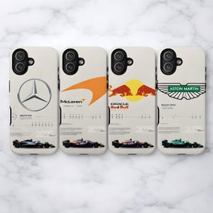 May include: Four phone cases with Formula 1 racing designs. Each case features a different team logo: Mercedes, McLaren, Oracle Red Bull Racing, and Aston Martin. The cases have a cream background with team car illustrations.