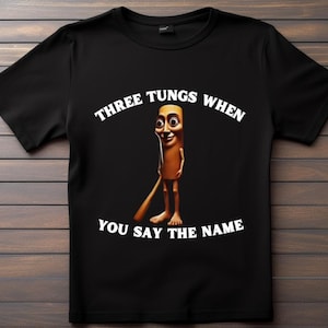 May include: Black t-shirt featuring a cartoon character with a long body and a smiling face. The text "THREE TUNGS WHEN YOU SAY THE NAME" is arched above and below the character in white letters.