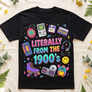 Może przedstawiać: Czarny t-shirt z kolorowym nadrukiem graficznym przedstawiającym ikony retro z lat 90. Projekt zawiera Tamagotchi, Game Boy, dyskietkę, kasetę magnetofonową, rolkę, płytę CD, kontroler, Furby i napis "Literally From The 1900's".
