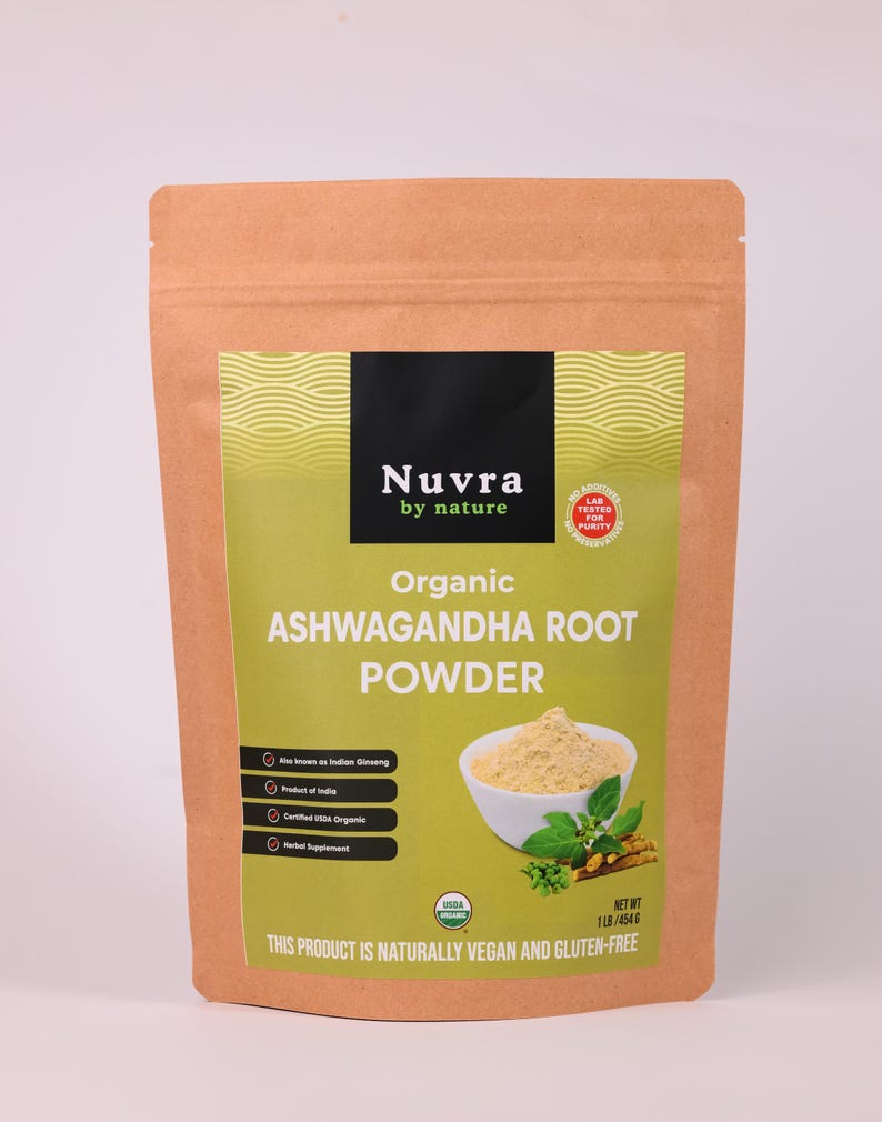 May include: A brown paper bag of organic ashwagandha root powder. The label features the brand name "Nuvra by nature" and the text "Organic Ashwagandha Root Powder." The bag also states the product is vegan and gluten-free, with a net weight of 1lb/454g.
