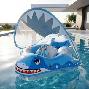 Puede incluir: Flotador de piscina inflable azul con forma de tiburón y parasol. El flotador presenta un diseño de cara de tiburón con dientes rojos y un parasol blanco y azul. Las palabras "Swim Bobo" están impresas en el flotador.