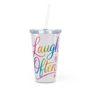 May include: A clear plastic tumbler with a white background and rainbow-coloured script reading "Laugh Often." The tumbler has a clear lid and a clear straw. The design includes small hearts and sunbursts.