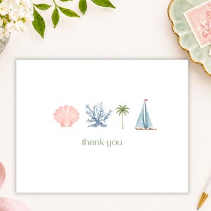 May include: A white rectangular thank you card featuring a horizontal row of four watercolor illustrations: a pink seashell, a blue coral branch, a green palm tree, and a blue sailboat. The text thank you is printed in a simple green font below.