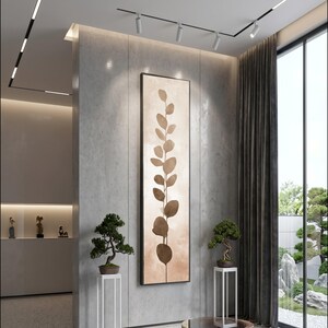 Può includere: Un interno moderno con una grande opera d'arte astratta verticale con un design botanico marrone. Due bonsai sono posti su piedistalli bianchi, che fiancheggiano l'opera d'arte. La stanza ha una palette di colori neutri e una grande finestra.