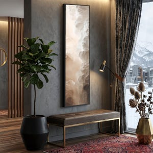 May include: A modern interior scene featuring a large framed artwork with a cloudscape design. A brown leather bench with gold-colored legs sits below the artwork. A tall potted plant and a floor lamp are also present, along with a patterned rug.