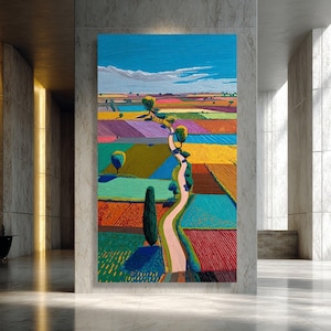 May include: A vertical oil painting on canvas depicting a vibrant landscape with a winding dirt path cutting through colorful rectangular fields of red, yellow, blue, and green. Scattered trees line the path under a bright blue sky with clouds.