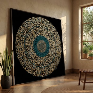 May include: Large framed artwork featuring a spiral design of gold calligraphy on a black background. The center of the spiral is teal. The artwork is leaning against a wall in a room with a window and a potted plant. The artwork is a decorative piece.