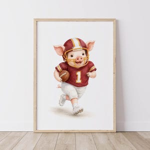 May include: A framed watercolor illustration of a piglet wearing a maroon and gold football helmet and a matching maroon jersey with the number one in white. The piglet is running while holding a brown football and wearing white cleats.