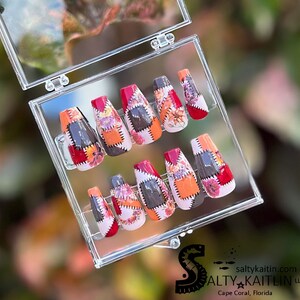 May include: A set of ten false nails with a patchwork design featuring red, orange, brown, and white colors. The nails are in a clear plastic box.
