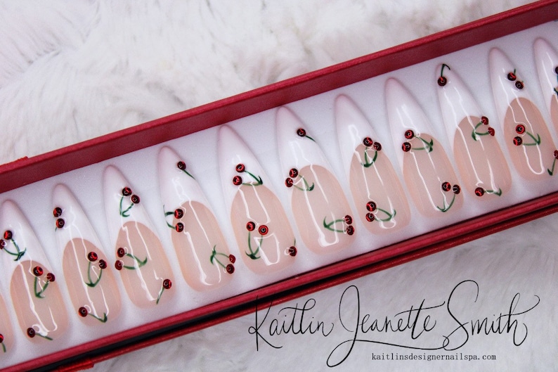 Cerezas con diamantes de imitación en uñas de gel francesas